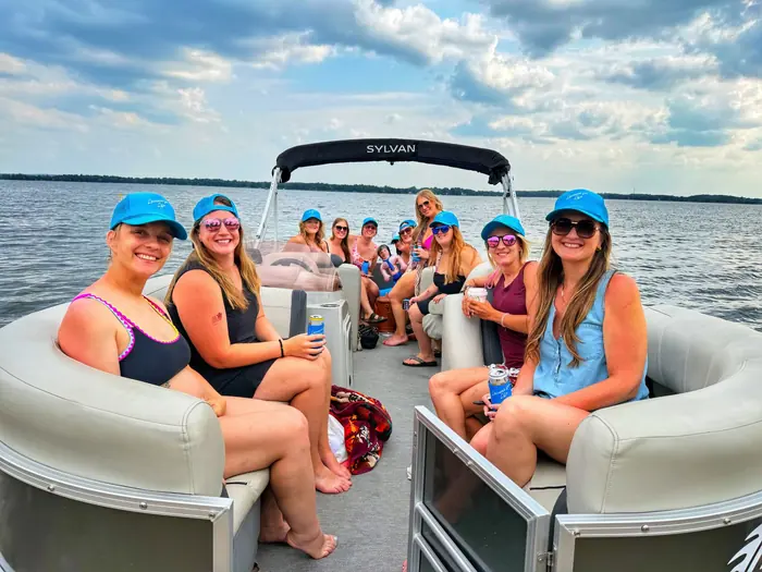 A bachelorette party in matching blue hats aboard the Baxstar Outdoors Sylvan pontoon on Detroit Lake