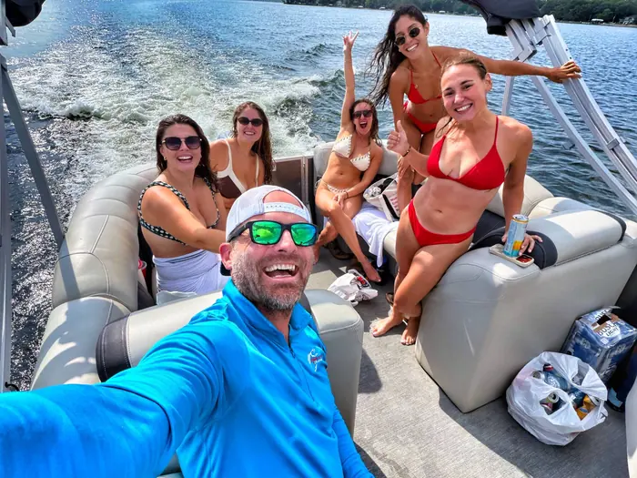 Captain Brady Baxter taking a selfie with guests on the pontoon under way