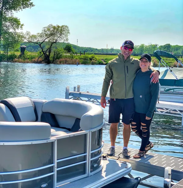 Baxstar Outdoors owners Brady and Jackie Baxter standing on the pontoon at a dock